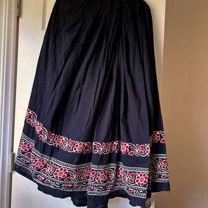 Long black stretch waist with tie skirt. Floral design  around hem